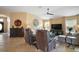 Comfortable living room with neutral color palette, modern ceiling fan, and view of the front entrance at 2882 Adrienne Way, The Villages, FL 32163