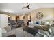 Spacious living room with neutral decor, large ceiling fan, and a view into the kitchen at 2882 Adrienne Way, The Villages, FL 32163