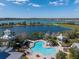 Aerial view of a community pool with slide overlooking the lake and houses at 303 White Water Bay Dr, Groveland, FL 34736