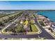 Aerial view of a suburban neighborhood featuring well-maintained homes, a lake and easy access to the highway at 303 White Water Bay Dr, Groveland, FL 34736