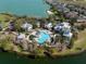 Aerial view of resort-style pool and clubhouse surrounded by trees near lake and community at 303 White Water Bay Dr, Groveland, FL 34736