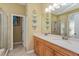 Bright bathroom with double sinks, light wood cabinets, and glass door shower at 303 White Water Bay Dr, Groveland, FL 34736