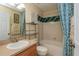 Cozy bathroom featuring tiled shower and tub, vanity sink, and decorative blue curtains at 303 White Water Bay Dr, Groveland, FL 34736