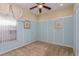 Pastel blue bedroom with light brown carpet, ceiling fan, and natural light from window at 303 White Water Bay Dr, Groveland, FL 34736