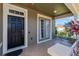 Inviting front porch with tiled flooring, a bench, and stylish black front door with sidelight windows at 303 White Water Bay Dr, Groveland, FL 34736