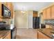 Modern kitchen featuring stainless steel appliances, granite countertops, and warm wood cabinetry at 303 White Water Bay Dr, Groveland, FL 34736