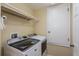 Well-lit laundry room with a modern washer and dryer and ample storage space at 303 White Water Bay Dr, Groveland, FL 34736