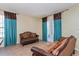 Cozy living room with beautiful brown sofas, tile floor, and large windows with attractive curtains at 303 White Water Bay Dr, Groveland, FL 34736