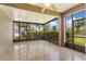 Relaxing screened-in patio with tile flooring, ceiling fan, and views of the landscaped backyard at 303 White Water Bay Dr, Groveland, FL 34736