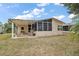 Rear exterior view of the home featuring a screened lanai and patio at 313 Westwood Dr, Leesburg, FL 34748