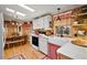 Quaint kitchen featuring skylights, wood paneling, white appliances and white cabinets at 313 Westwood Dr, Leesburg, FL 34748