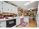 Bright kitchen with skylights, a large farm sink, wood paneling, and white appliances at 313 Westwood Dr, Leesburg, FL 34748