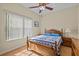 Bright bedroom features a wood bed frame, fan, and a large window at 3206 Sonesta Ct # A, Clermont, FL 34711