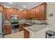 Well-lit kitchen featuring granite countertops, stainless steel appliances, and wood cabinets at 3206 Sonesta Ct # A, Clermont, FL 34711