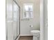 Bathroom with frosted glass shower door, geometric wallpaper, and a modern toilet at 32222 Summertree Circle, Leesburg, FL 34748