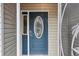 Close up of the front door showing its blue color, design, and sidelight window at 32222 Summertree Circle, Leesburg, FL 34748