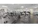 Spacious gym with modern equipment including treadmills, weights and other exercise machines on dark floors and bright lighting at 32222 Summertree Circle, Leesburg, FL 34748