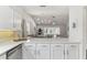 Kitchen featuring white cabinetry, marble countertops, and an open layout to the dining area at 32222 Summertree Circle, Leesburg, FL 34748