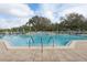 Community pool with several lanes, tables, umbrellas, and lounge chairs on the pool deck at 32222 Summertree Circle, Leesburg, FL 34748