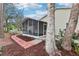 Exterior of screened-in porch with a brick pathway surrounded by trees at 32222 Summertree Circle, Leesburg, FL 34748