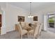 Elegant dining room with a glass-top table, six chairs, chandelier, and access to the patio at 3262 Dalkeith Ter, The Villages, FL 32163