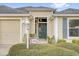 Inviting front entryway with a dark-colored door, well-lit porch, and manicured landscaping at 3262 Dalkeith Ter, The Villages, FL 32163