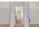 Hallway leading into a bathroom with tile flooring and two walk-in closets on either side at 3262 Dalkeith Ter, The Villages, FL 32163