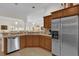 Bright kitchen with stainless steel appliances, tile flooring, and wood cabinetry at 3262 Dalkeith Ter, The Villages, FL 32163