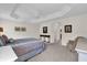 Bright primary bedroom with tray ceiling, carpeting, and ensuite bathroom at 3262 Dalkeith Ter, The Villages, FL 32163