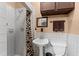 Cozy bathroom featuring a tiled shower, pedestal sink, and coordinated fixtures at 330 N Sunset Dr, Mount Dora, FL 32757