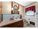 Charming bathroom with traditional fixtures, an oval mirror and white and blue tile at 330 N Sunset Dr, Mount Dora, FL 32757