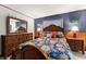 Cozy bedroom featuring wood furniture, lamps, and a decorative floral-patterned comforter at 330 N Sunset Dr, Mount Dora, FL 32757