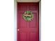 A welcoming red front door featuring a decorative wreath with a 'welcome' sign at 330 N Sunset Dr, Mount Dora, FL 32757