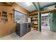 Well-lit laundry room featuring a modern washer and dryer set, storage shelves, and access to a screened-in porch at 330 N Sunset Dr, Mount Dora, FL 32757