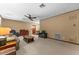 A large carpeted living room featuring a ceiling fan, furniture, and ample space at 330 N Sunset Dr, Mount Dora, FL 32757