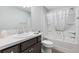 Bathroom featuring dark wooden cabinets, a large mirror, and a shower-tub combo with decorative curtain at 3320 Davis Ter, The Villages, FL 32163