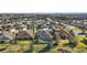 Expansive aerial view of a neighborhood featuring single-Gathering homes, manicured lawns, and mature trees in a planned community at 3426 Boardroom Trl, The Villages, FL 32163