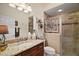 Well-lit bathroom featuring granite countertops and a glass-enclosed shower with decorative accents at 3426 Boardroom Trl, The Villages, FL 32163