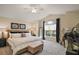 Spacious main bedroom with a large window, ceiling fan, and neutral décor at 3426 Boardroom Trl, The Villages, FL 32163