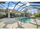 Luxurious screened-in pool area with comfortable seating, a built-in spa, and clear views of the backyard at 3426 Boardroom Trl, The Villages, FL 32163