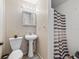 Cozy bathroom features wallpaper, white fixtures, and a shower with a striped curtain, offering essential functionality at 422 W Hunt Ave, Bushnell, FL 33513