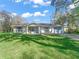 Charming single-story home featuring light paint, shuttered windows, and a well manicured green lawn at 422 W Hunt Ave, Bushnell, FL 33513