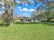 Charming single-story home featuring light paint, shuttered windows, and a well manicured green lawn at 422 W Hunt Ave, Bushnell, FL 33513