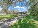 Lovely single story home with long driveway, mature trees, and green grass at 422 W Hunt Ave, Bushnell, FL 33513