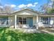 Front of home with a cozy porch, rocking chair, and blue door at 422 W Hunt Ave, Bushnell, FL 33513