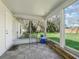 Enclosed porch for relaxation featuring tile floors and a view of the backyard and trees at 422 W Hunt Ave, Bushnell, FL 33513