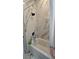 Bathtub and shower featuring marble tile surround at 42329 Chinaberry St, Eustis, FL 32736