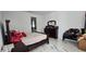 Cozy bedroom with marble tile flooring, a dresser, and a view into the bathroom at 42329 Chinaberry St, Eustis, FL 32736