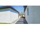 Property exterior showcasing a stone walkway between white stucco walls, enhanced by decorative plants at 42329 Chinaberry St, Eustis, FL 32736