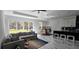 Bright living room featuring a grey sofa, a large sliding glass door, and modern marble flooring at 42329 Chinaberry St, Eustis, FL 32736